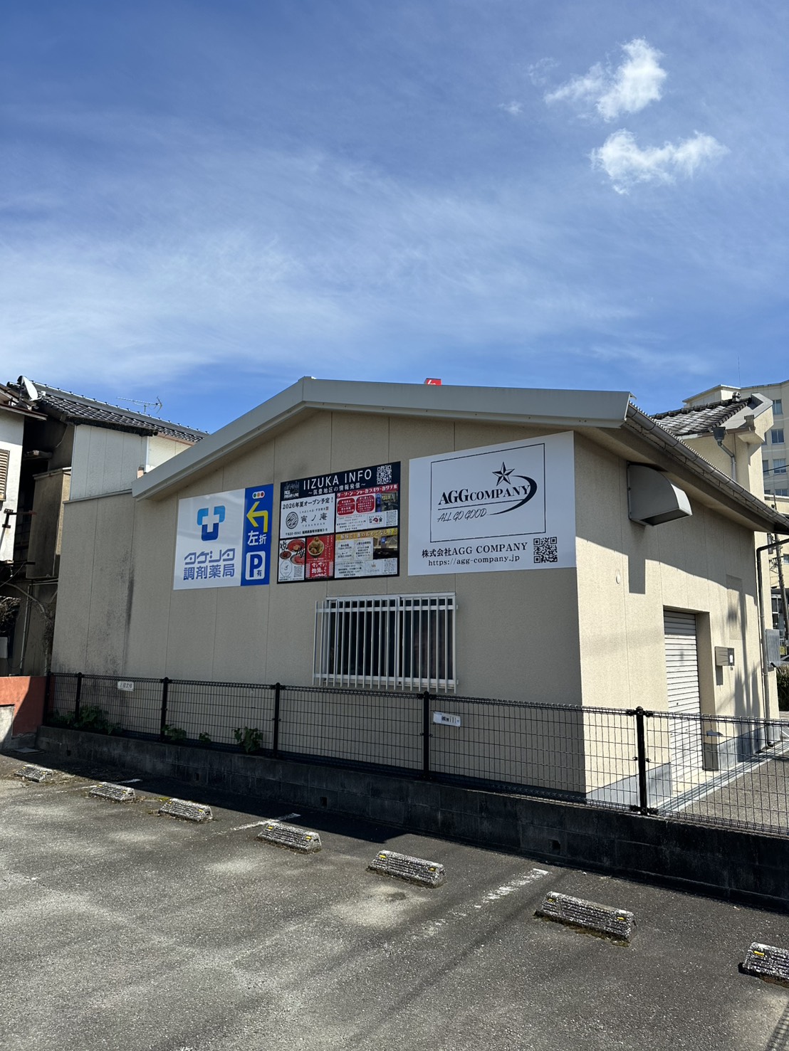 AGG COMPANYと地域情報の看板を掲出した本部事務所の外観